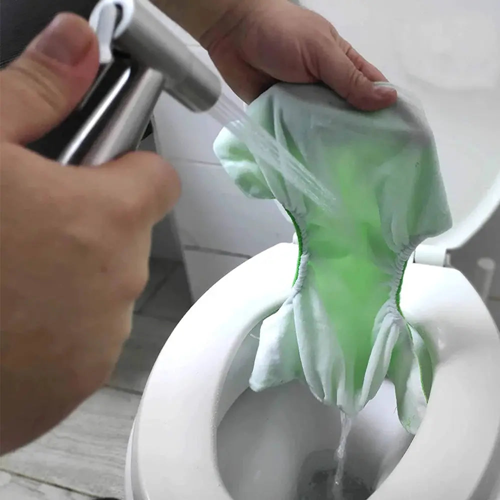 Handheld bidet spray on stainless steel hose being used on a toilet.