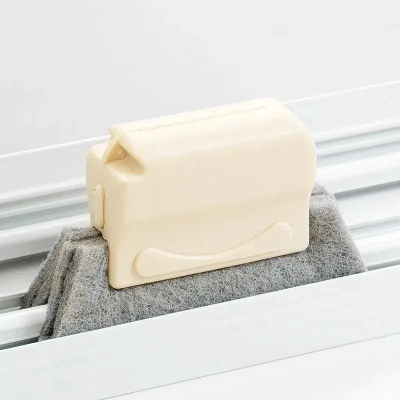 Groove cleaning brush for window tracks; beige plastic handheld tool.
