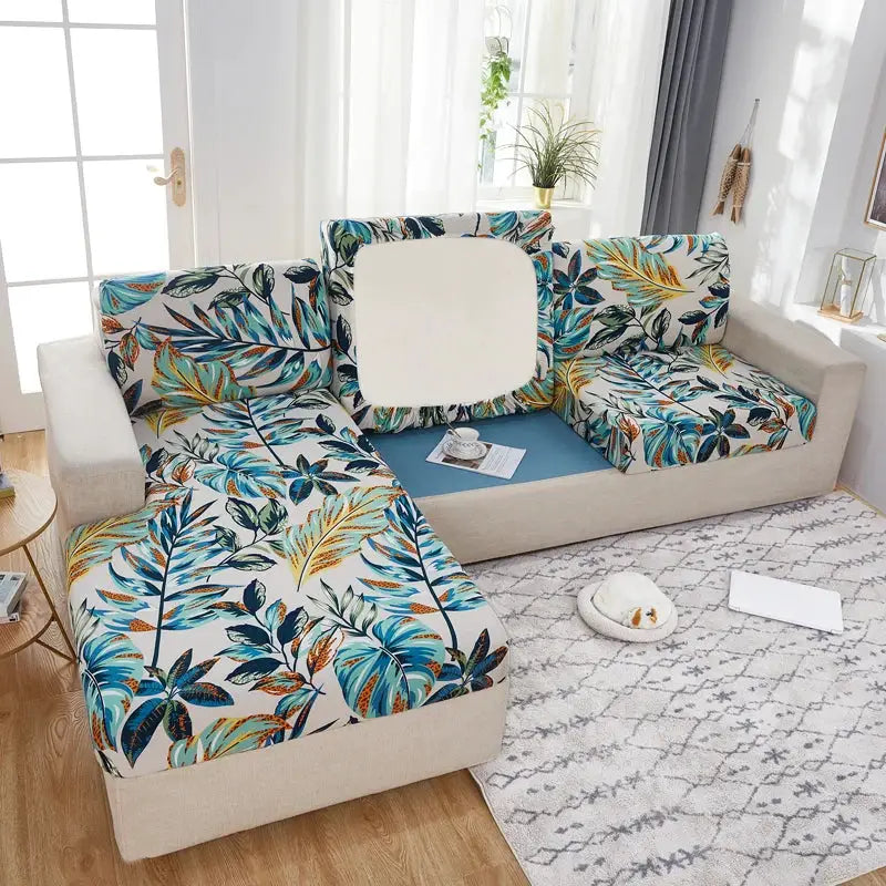 Geometric print sofa cover set for a corner sofa; teal, blue and orange leaf pattern with elastic stretch.