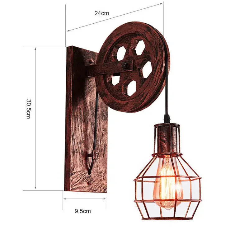 Vintage industrial wall sconce with copper-toned metal, pulley wheel and wire cage around an Edison bulb
