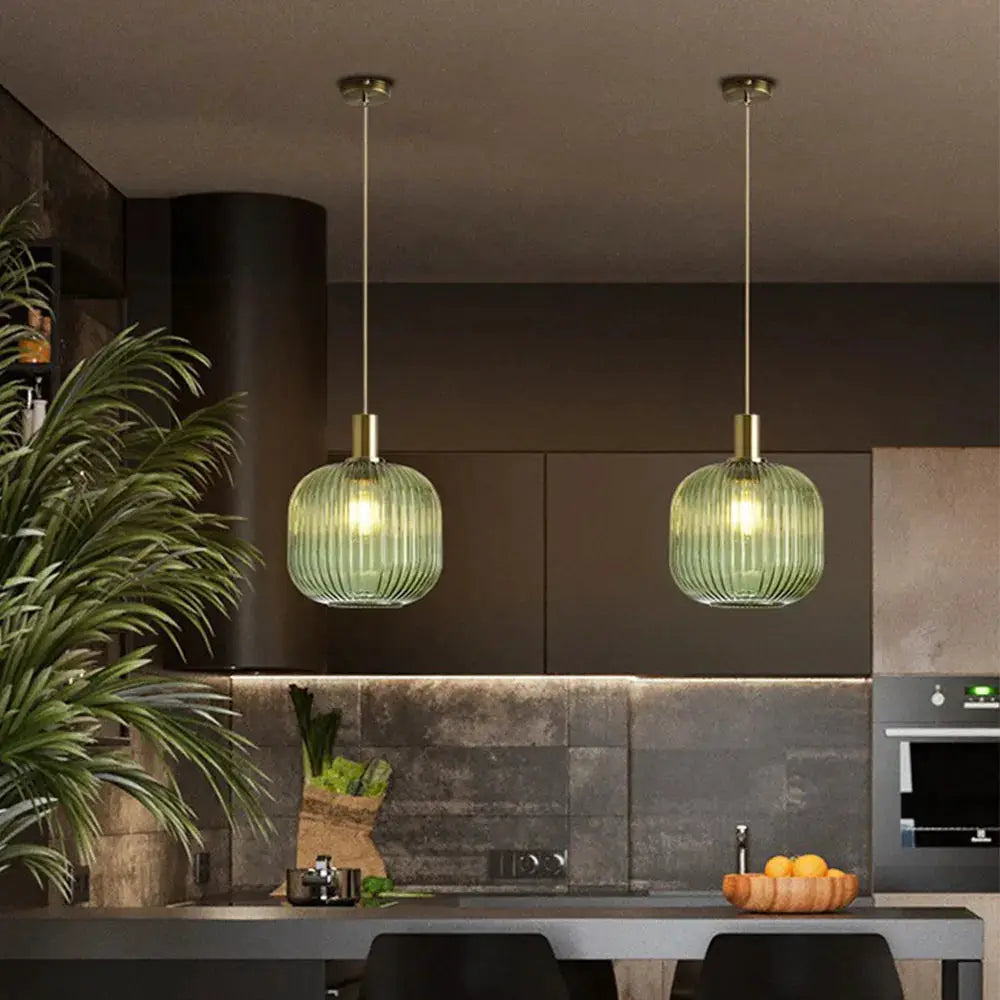 Pendant lights: two green ribbed glass fixtures with brass accents hanging above a kitchen island.