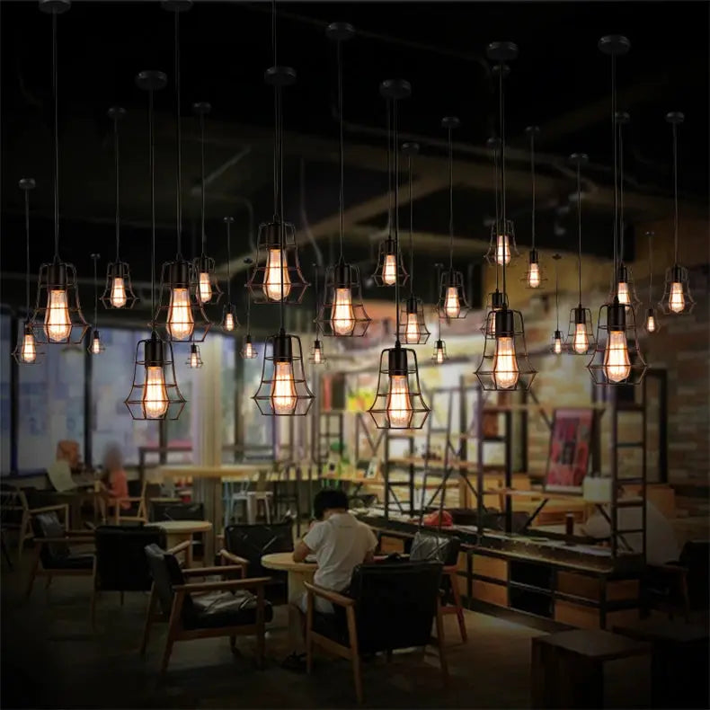 Industrial retro iron pendant lights; set of about 20 hanging lamps with warm Edison bulbs over a dining area