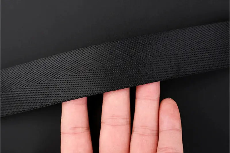 Women's black Oxford backpack strap close-up, showing durable textured webbing and sturdy stitching