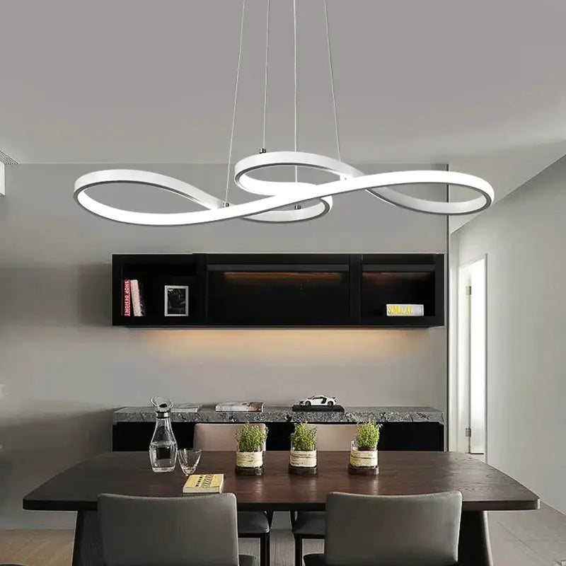 Modern kitchen island pendant lights with white LED infinity-loop design over dining table