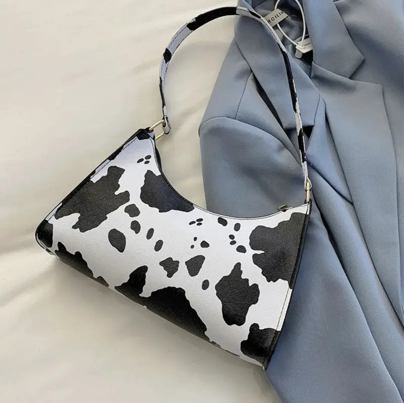 Shoulder bag in cow-print PU leather; white with black spots, curved top strap.