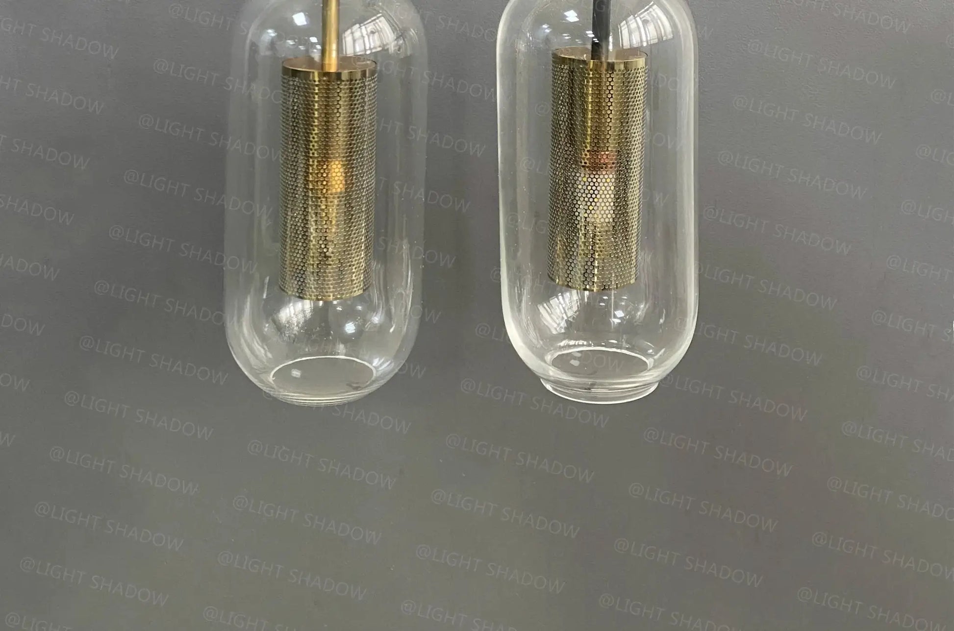 Modern glass wall light sconce pair by Simples Market with brass mesh inner cylinders and LED lamps