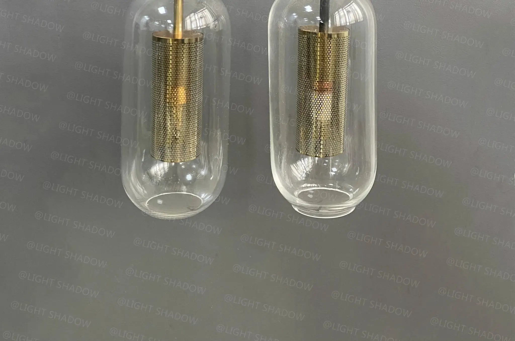 Modern glass wall light sconce pair by Simples Market with brass mesh inner cylinders and LED lamps