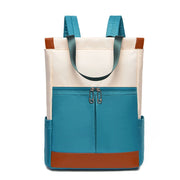 Women’s waterproof Oxford backpack in teal with beige top and brown base; front zip pocket.