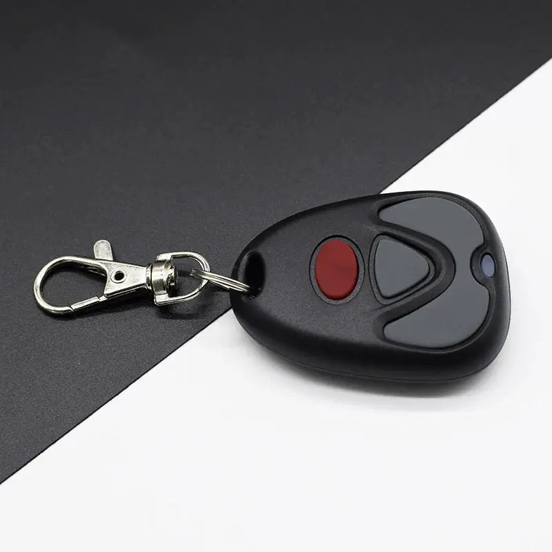Simples Market garage door remote control, black handheld transmitter with red and gray buttons on a keychain, 433MHz