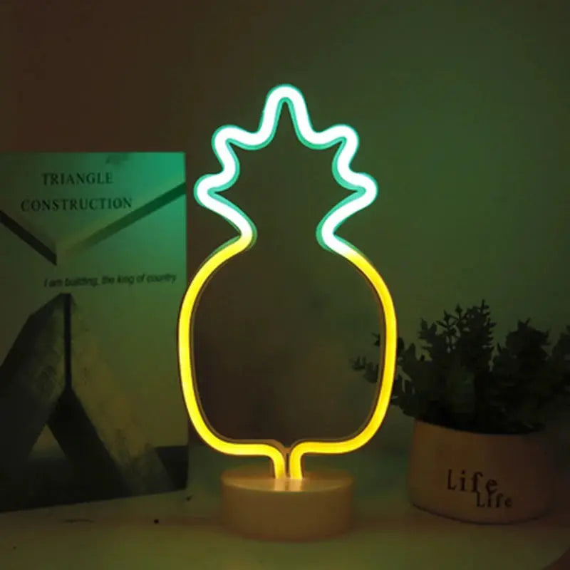 Neon pineapple-shaped USB LED night light with green crown and yellow body on a white base