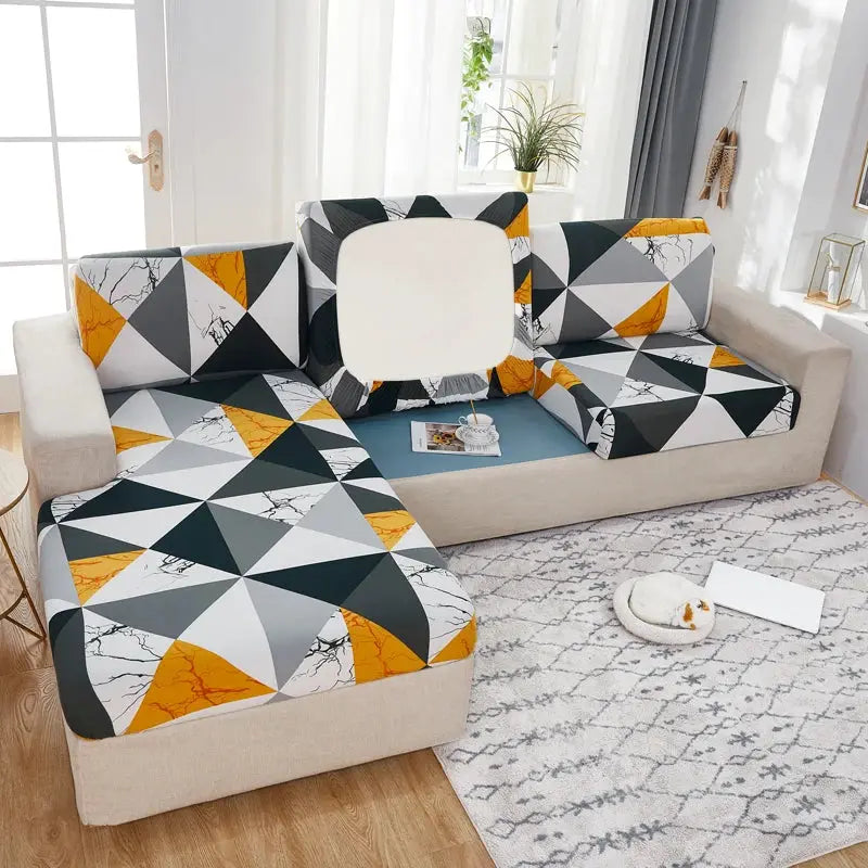 Geometric sofa cover by Simples Market for corner couch; slipcover in gray, black, white, orange triangles.