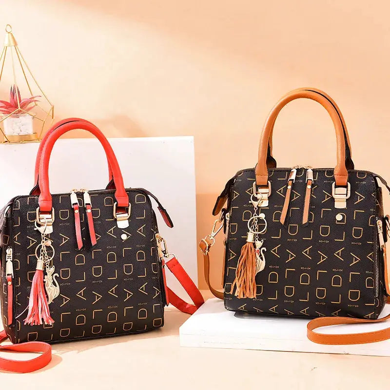 Two fashion English Letter PU leather handbags by Simples Market with tassels, black with red and tan handles.