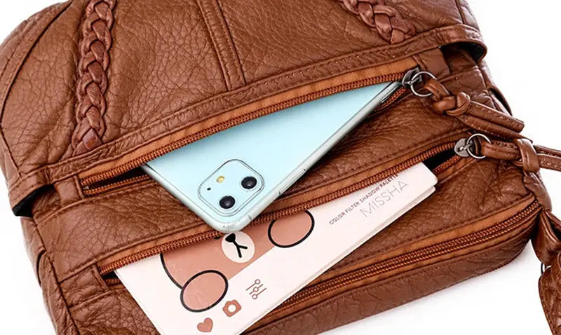 Simples Market brown PU leather messenger bag with multiple zip pockets; phone and card visible in front compartments.