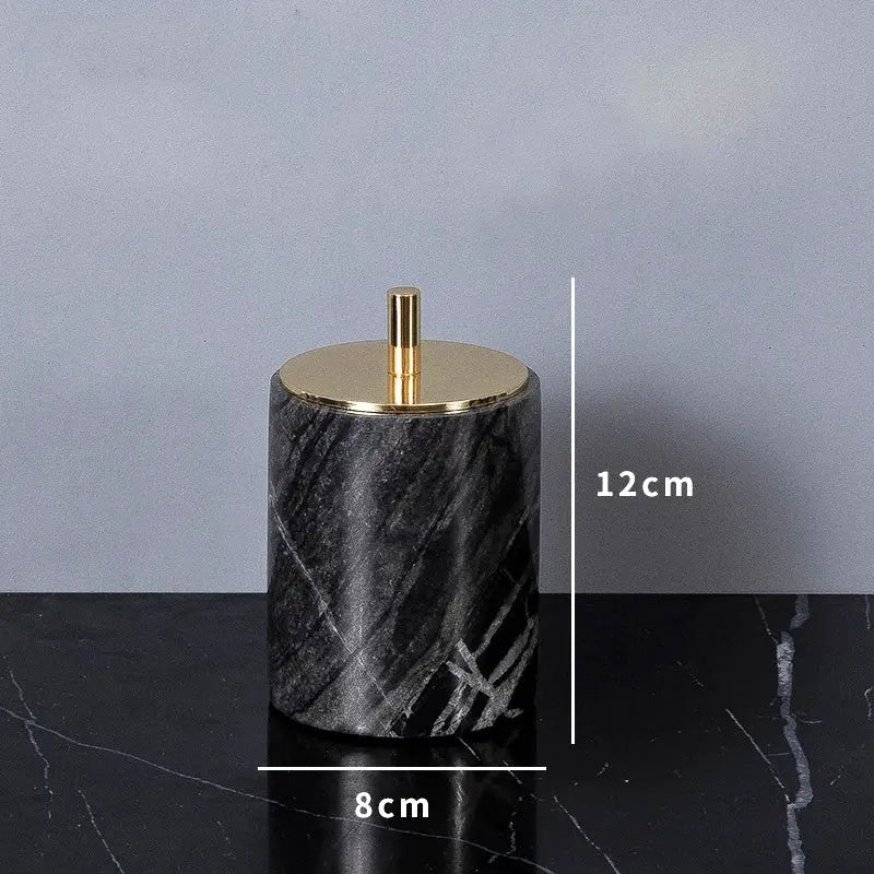 Soap dispenser in black marble with a gold pump, 12 cm tall cylindrical bathroom accessory.