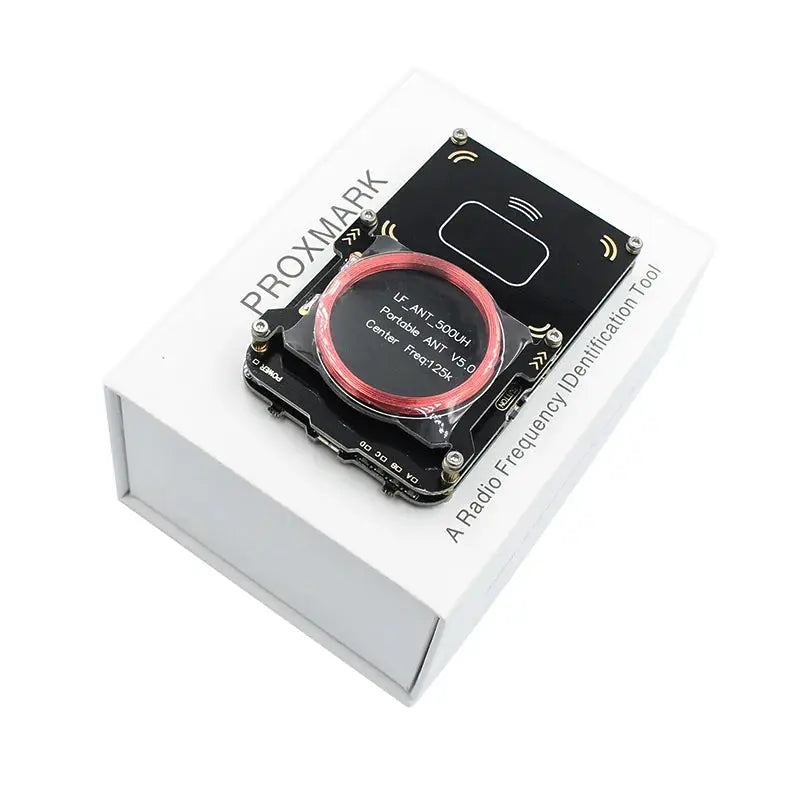 Proxmark3 RFID reader/writer kit with red coil on black PCB, displayed on a white box