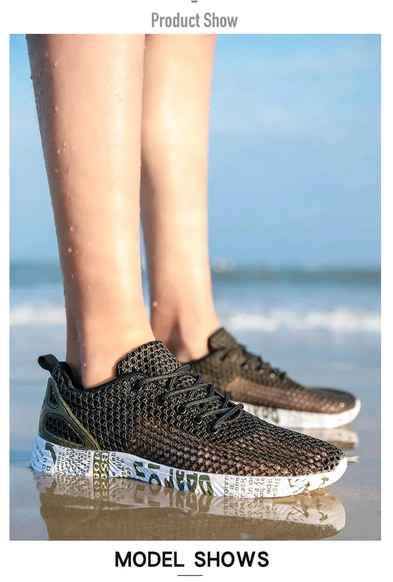 Pair of men's black mesh water shoes with foam soles on the beach