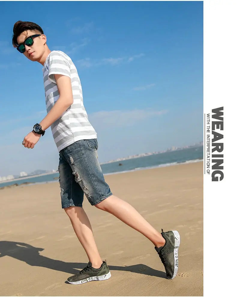 Men's olive-green mesh sneakers with foam sole worn on a sunny beach