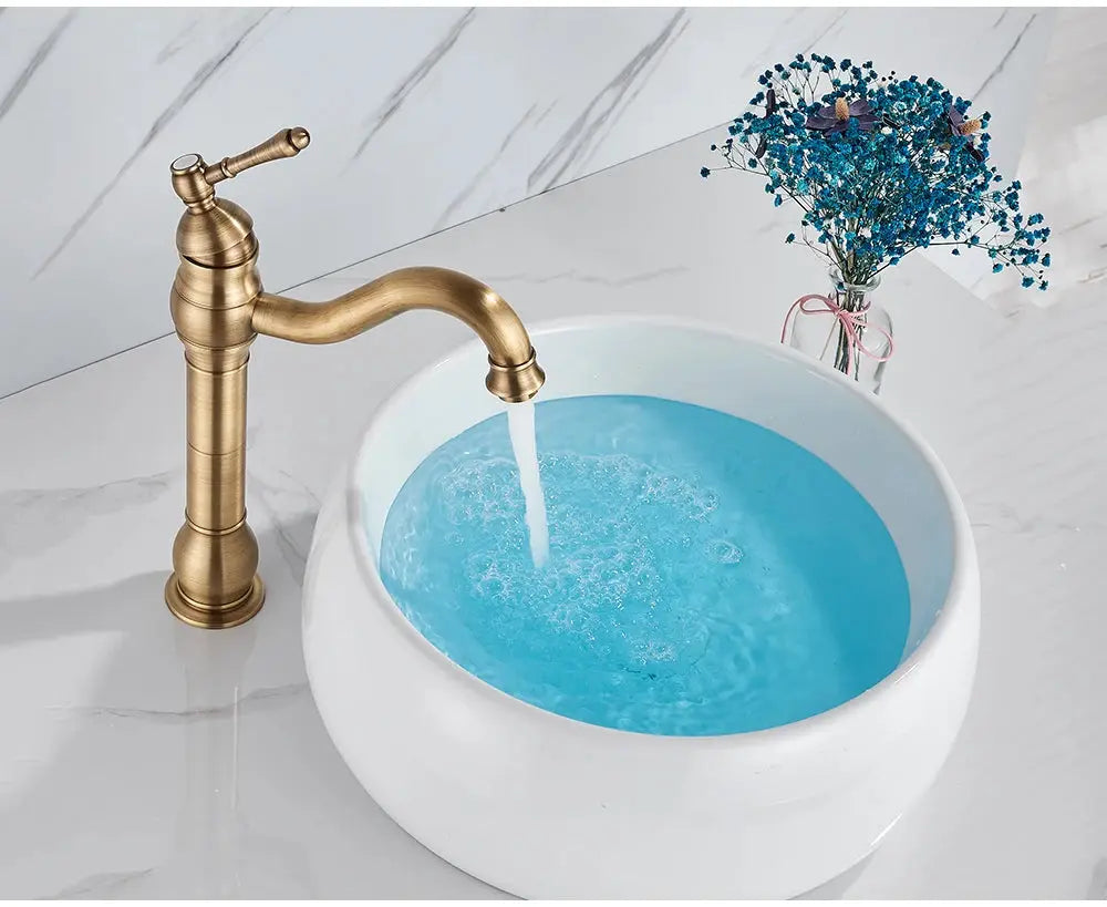 Simples Market antique brass basin faucet, deck-mounted, single-hole, pouring into a vessel sink with blue water