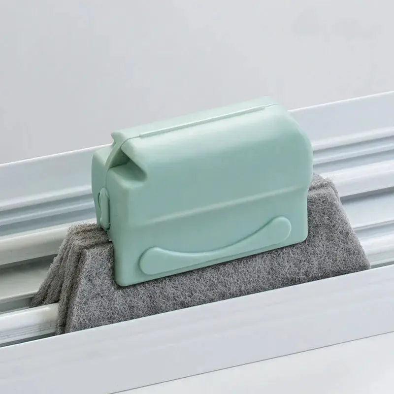 Groove cleaning brush for windows; mint green plastic body with gray felt pad.