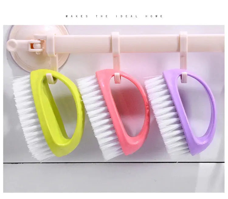 Egg-shaped cleaning brush set with soft white bristles in lime green, pink and purple, hanging on rack