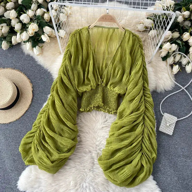 Chiffon draped blouse in olive green with puff long sleeves and smocked cropped waist.