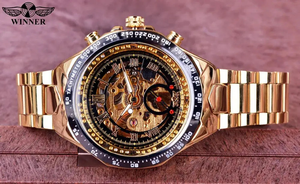 Winner gold-tone skeleton mechanical watch with black tachymeter bezel and gold bracelet