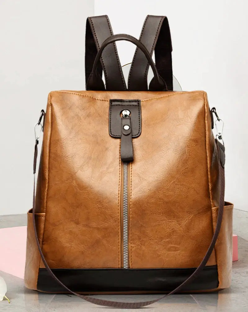 Tan PU leather anti-theft women's backpack with brown shoulder straps and front vertical zipper