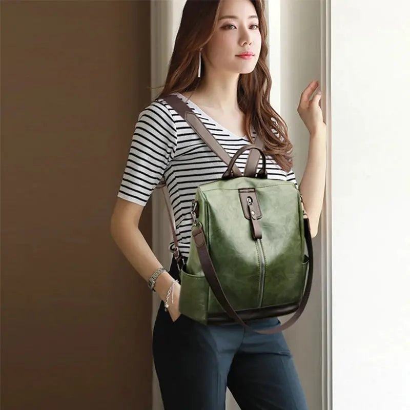 Backpack, green PU leather with brown straps, front buckle detail and roomy main compartment