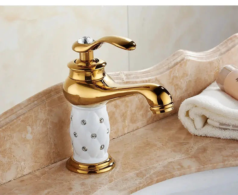 Bathroom faucet with antique bronze finish and white ceramic handle with crystal accents, single-handle basin mixer.