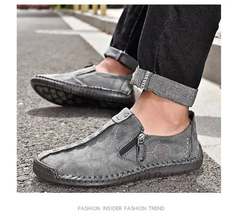 Pair of gray leather men’s slip-on moccasin loafers with side zipper and stitching.
