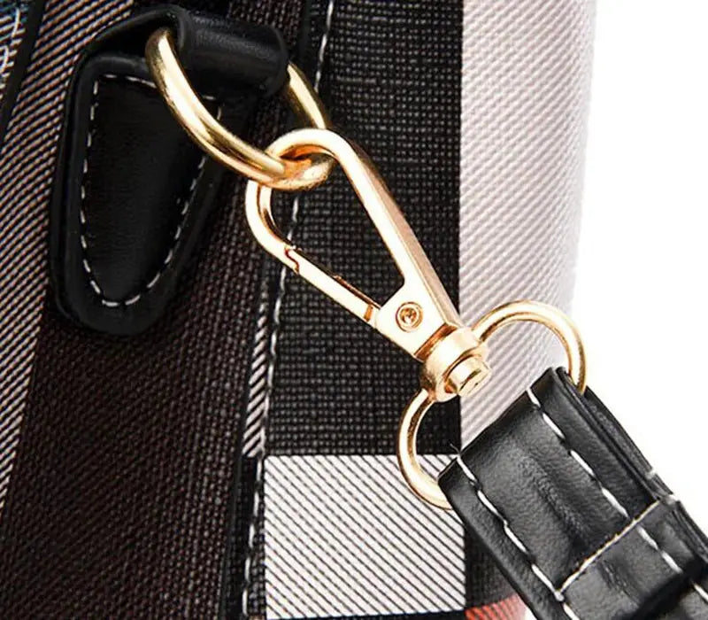 Crossbody bag with black PU leather strap and gold-tone hardware on checkered fabric exterior