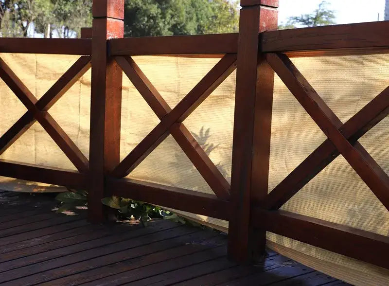 Tewango 95% UV HDPE sun shade net for balcony privacy on brown wooden railing.