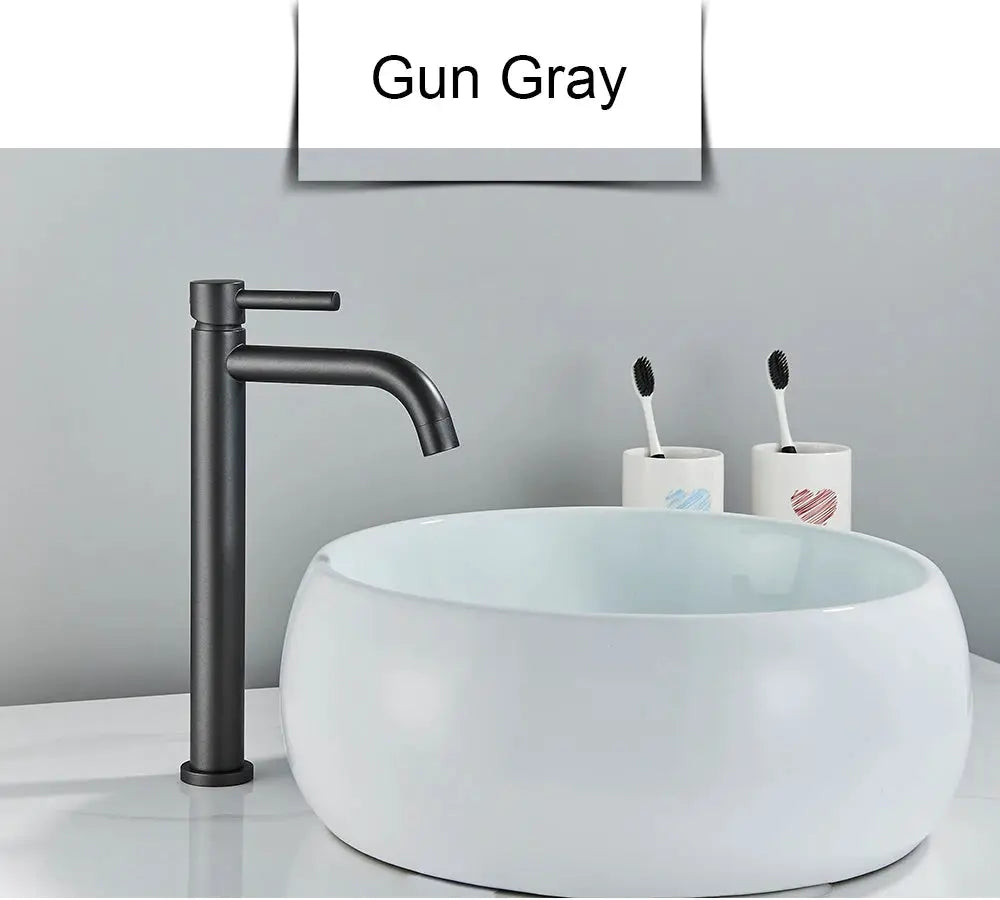 Black brushed-finish basin faucet for bathroom with tall cylindrical body and curved spout beside a white ceramic basin.