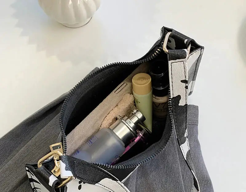 Simples Market zebra-print shoulder bag in PU leather with top zipper; interior holds cosmetics and bottles