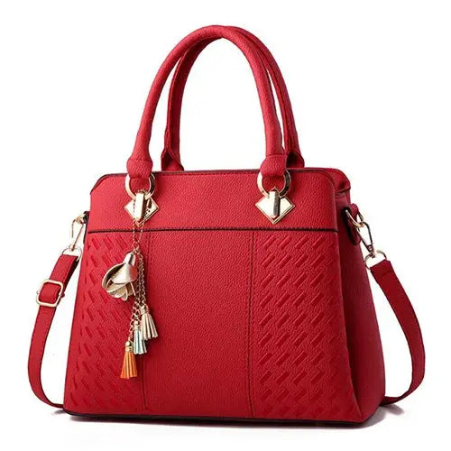 Simples Market red PU leather handbag with top handles, crossbody strap and tassel charms