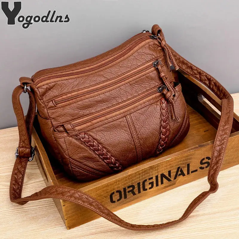 Women’s PU leather messenger bag in brown with braided strap and multiple zip pockets