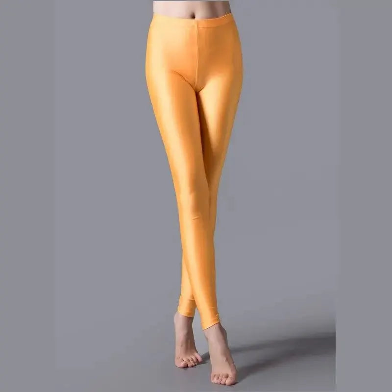 Women's shiny orange leggings in fluorescent stretch spandex; casual fit.