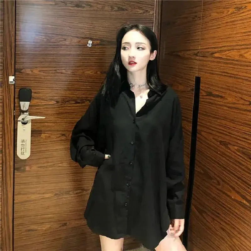 Oversized women's black button-up shirt, long sleeves, tunic-length blouse.