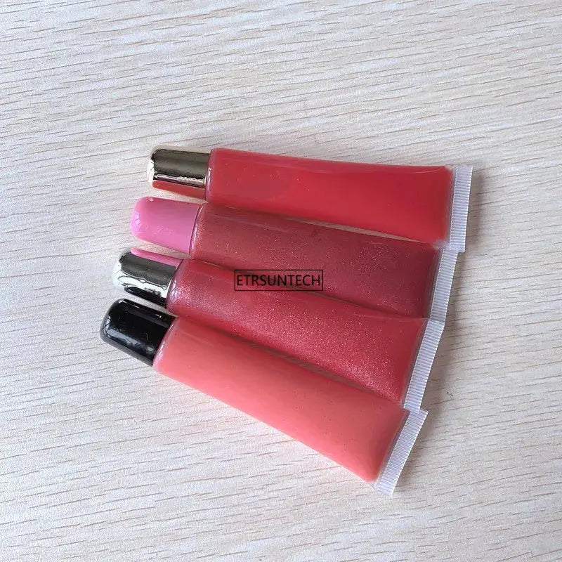Lip gloss squeeze tubes set of 4 with clear bodies and metallic caps in pink-red shades; ETRSUNTECH label visible