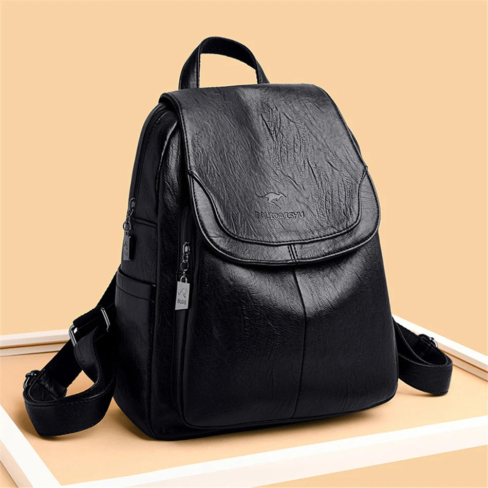 Black genuine leather backpack for women with flap front, top handle, and adjustable straps.