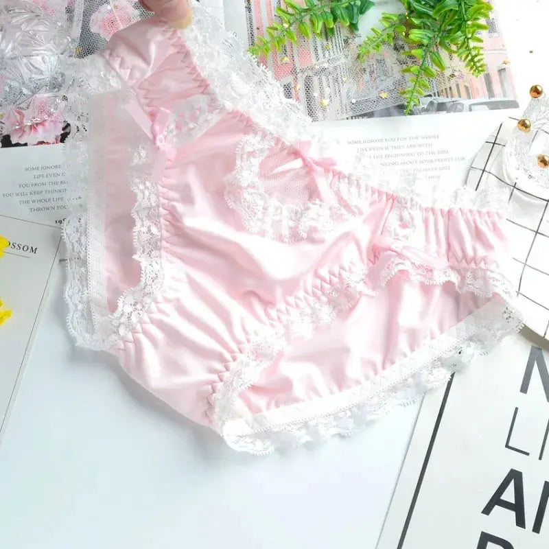 Pink milk-silk lace panties with white frill trim, low-rise brief.