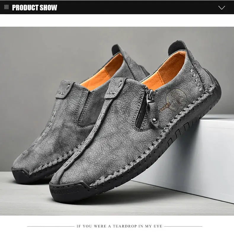 Men's grey leather slip-on loafers with moccasin stitching and orange lining