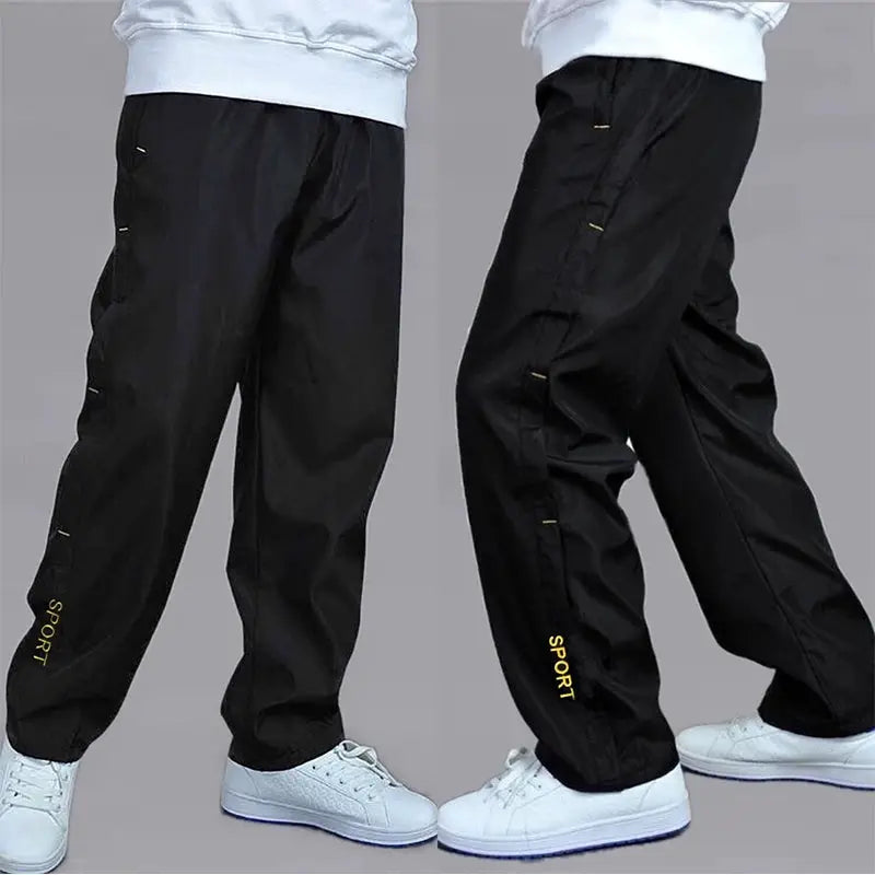 Men's black sweatpants with loose straight leg and yellow SPORT branding on the lower leg.