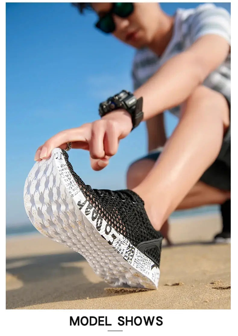 Origin Air Mesh Sneakers for men, black mesh upper with white foam sole on the beach