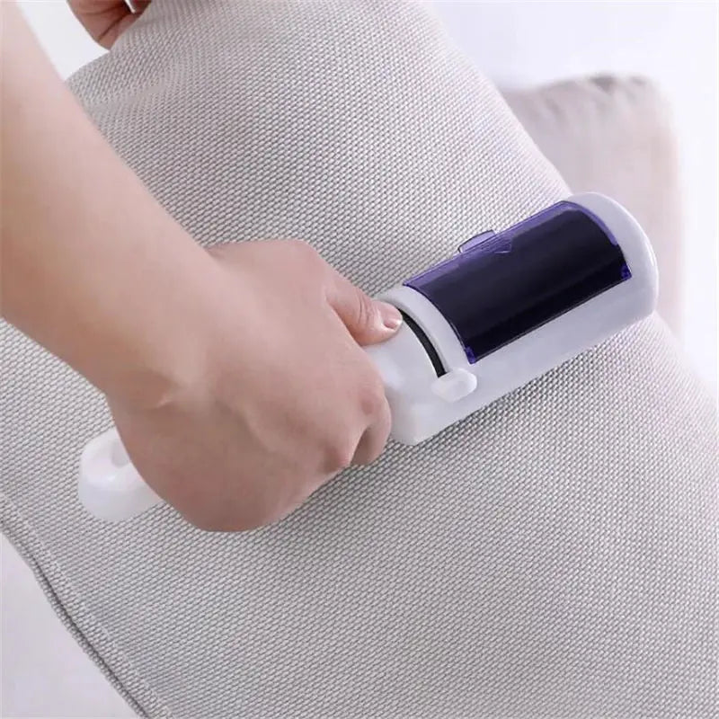 Electrostatic lint roller for clothes with white handle and purple roller removing pet hair from fabric.