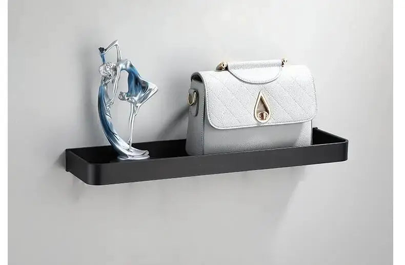 Bathroom wall-mounted black aluminum shelf with a quilted handbag on display