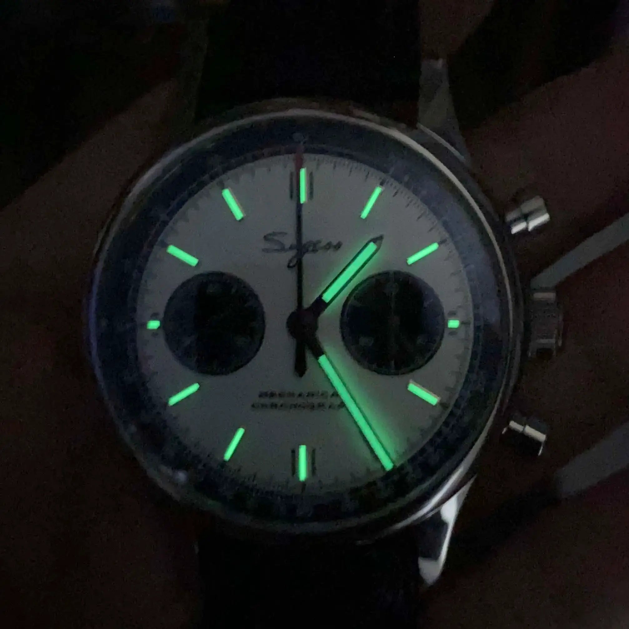 Pilot chronograph wristwatch with grey dial, two subdials, and glowing green markers.