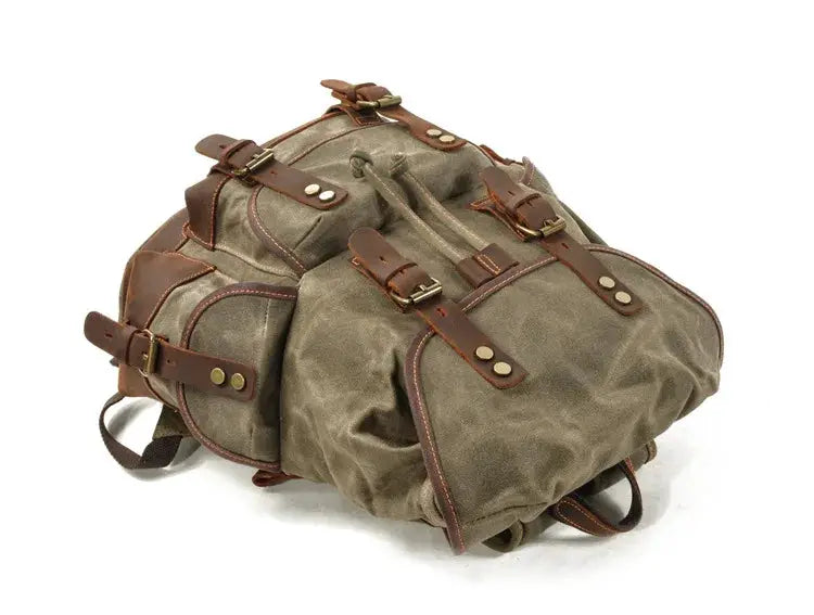 Vintage canvas backpack by Simples Market with brown leather straps and brass hardware