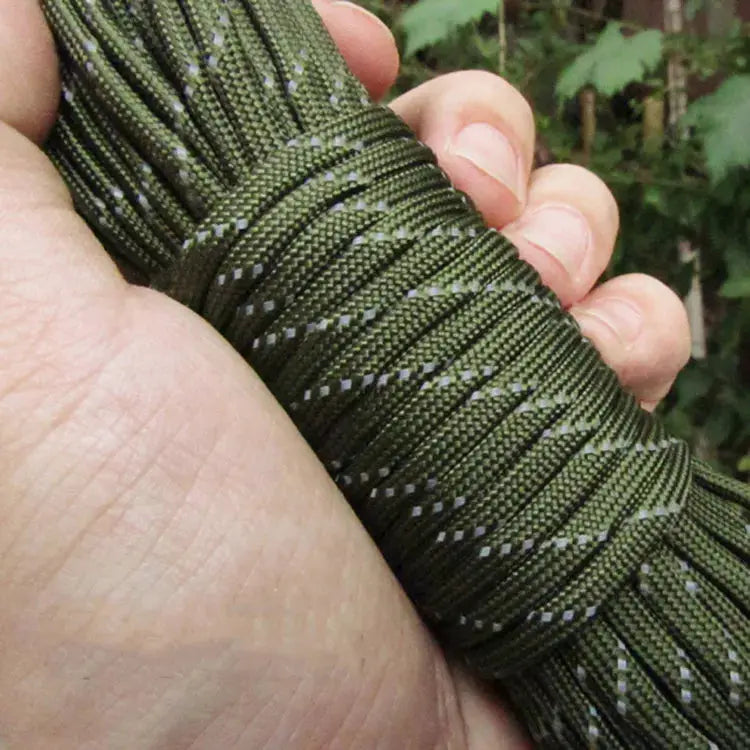 Reflective olive-green paracord rope, 4mm 7-strand cord, coiled in hand for camping and DIY bracelet weaving.