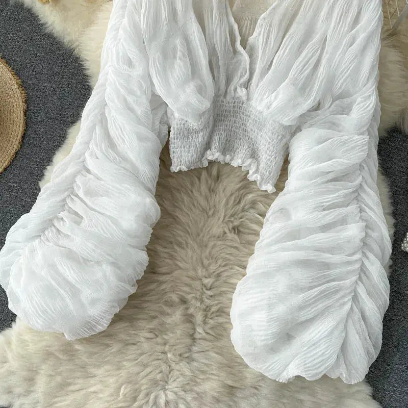 White chiffon draped blouse with puff long sleeves, V-neck, sheer crinkled fabric, and smocked waist from Simples Market